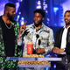 (L-R) Black Panther actors Winston Duke (wearing a tracksuit from Nike’s Nigeria World Cup Kit), Chadwick Boseman, and Michael B. Jordan accept the Best Movie award for ‘Black Panther’ onstage during the 2018 MTV Movie And TV Awards on June 16, 2018.
